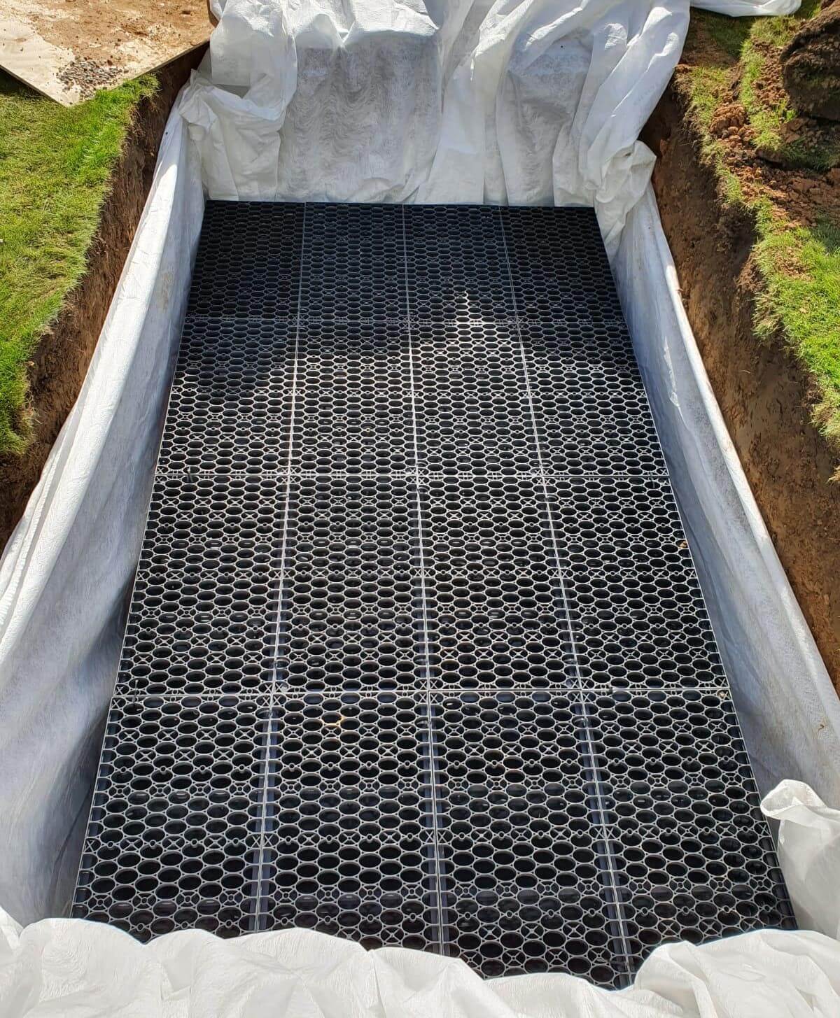 A set of soakaway crates in the ground wrapped in membrane